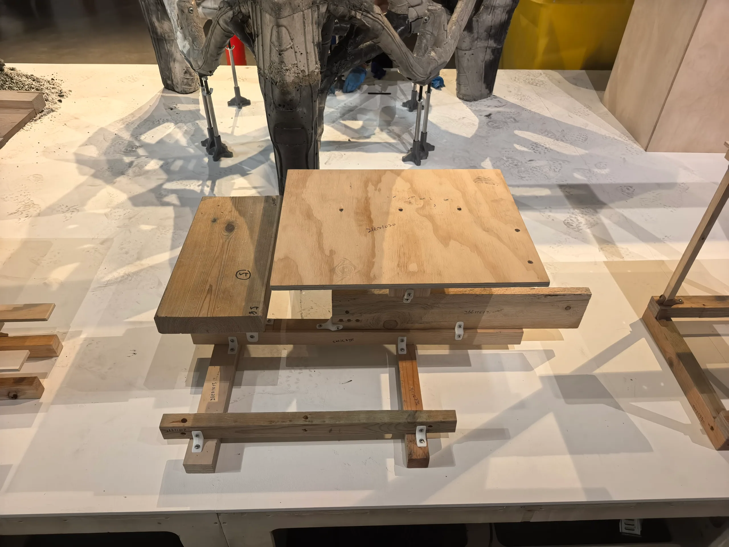 The Bartlett Autumn Show 2026: Khora 4: a seat and a top of boards on crossing timber bars, built from real stock and joined with white connectors